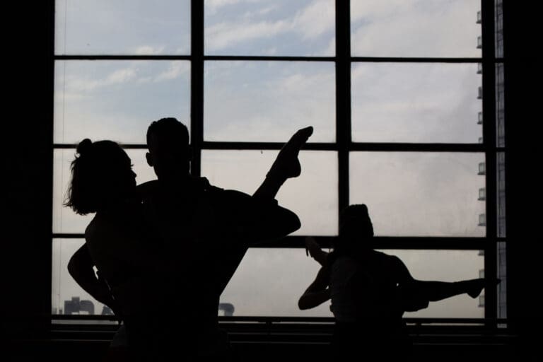 Dancers in Silhouette in front of a large window
